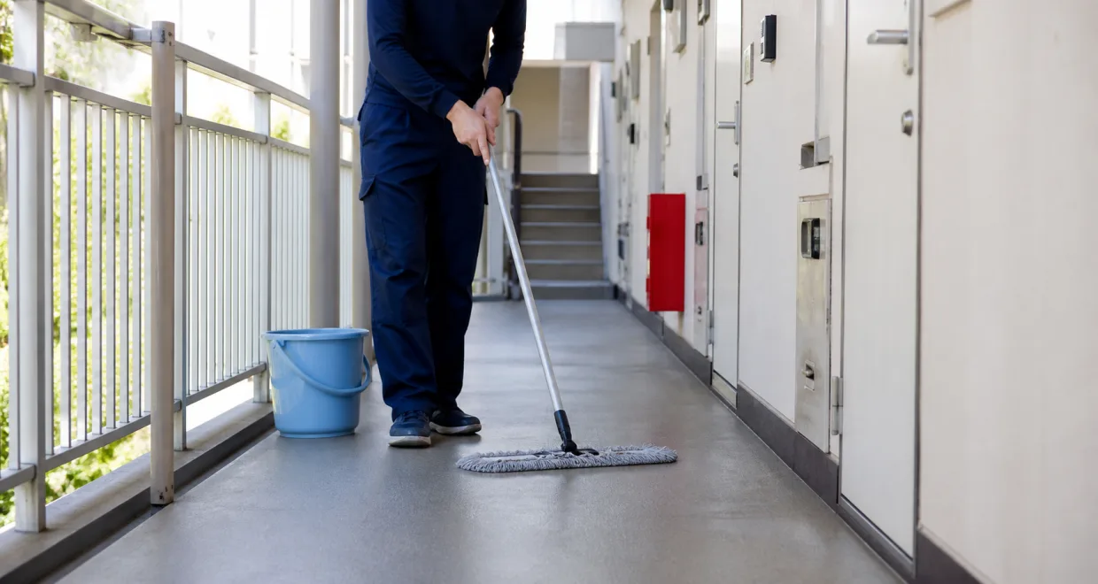賃貸物件の共用廊下を清掃する様子